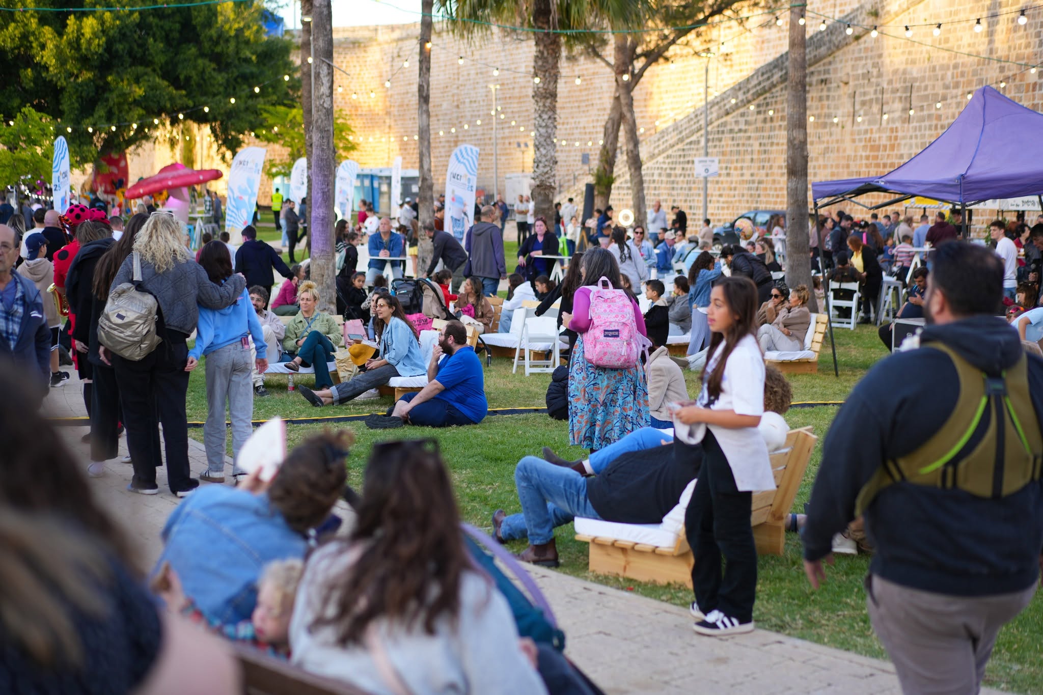 Visitors sit and stroll through the festival grounds by day.