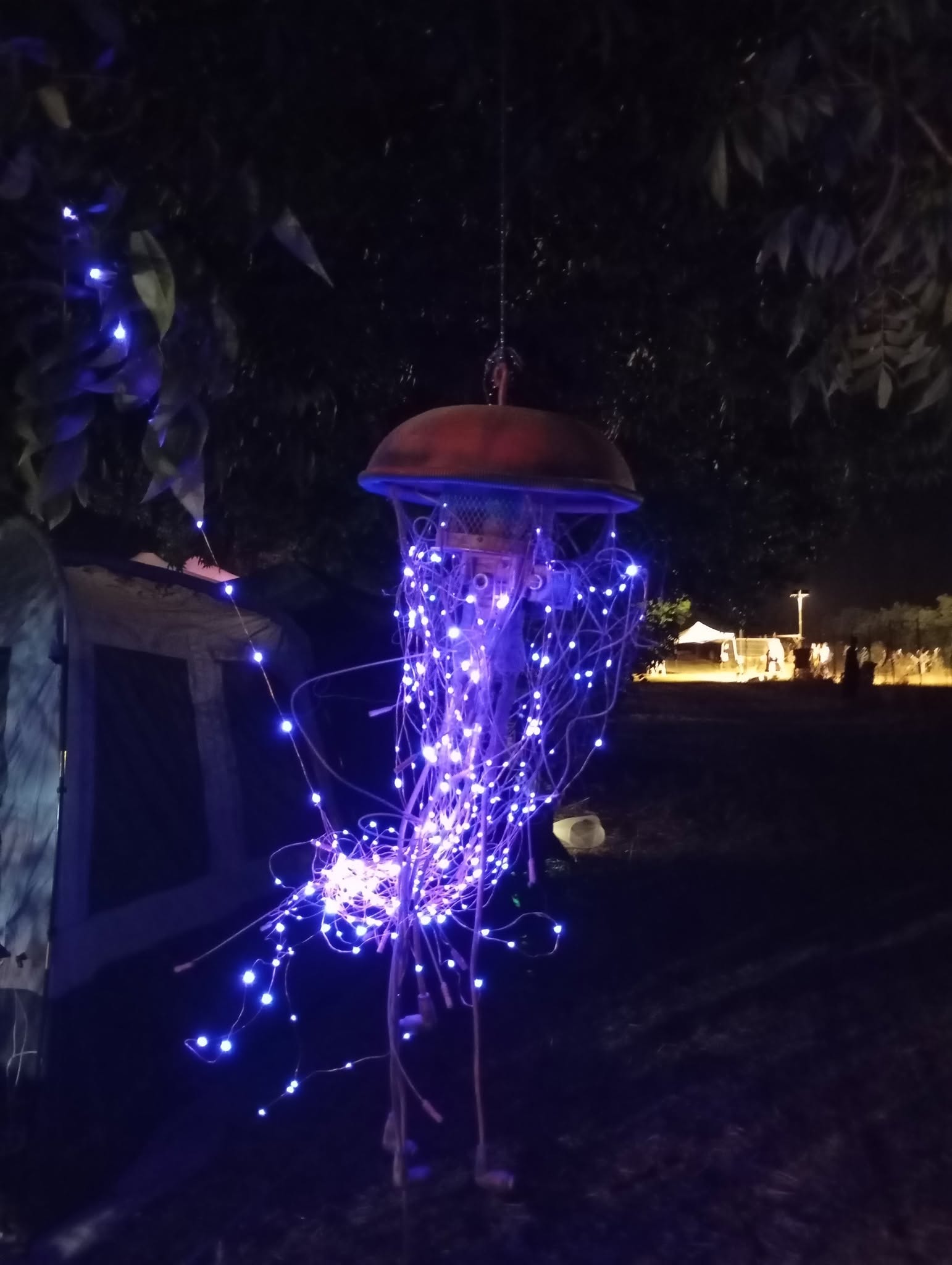 A small mushroom-shaped installation glows purple at night.