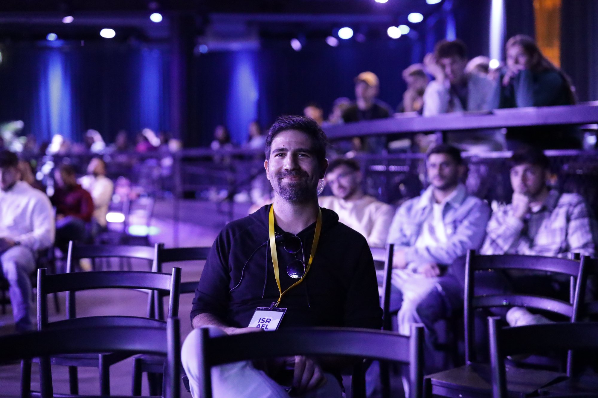 An attendee sits among the rows of chairs at the conference.