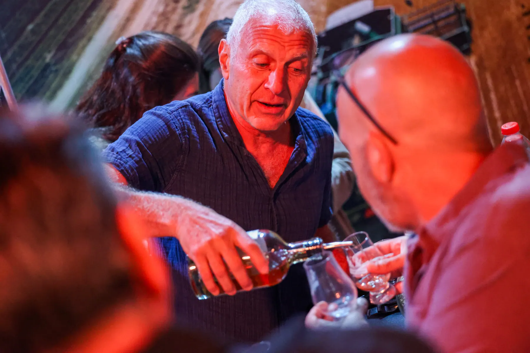 A bartender serves a drink to a visitor across the counter.