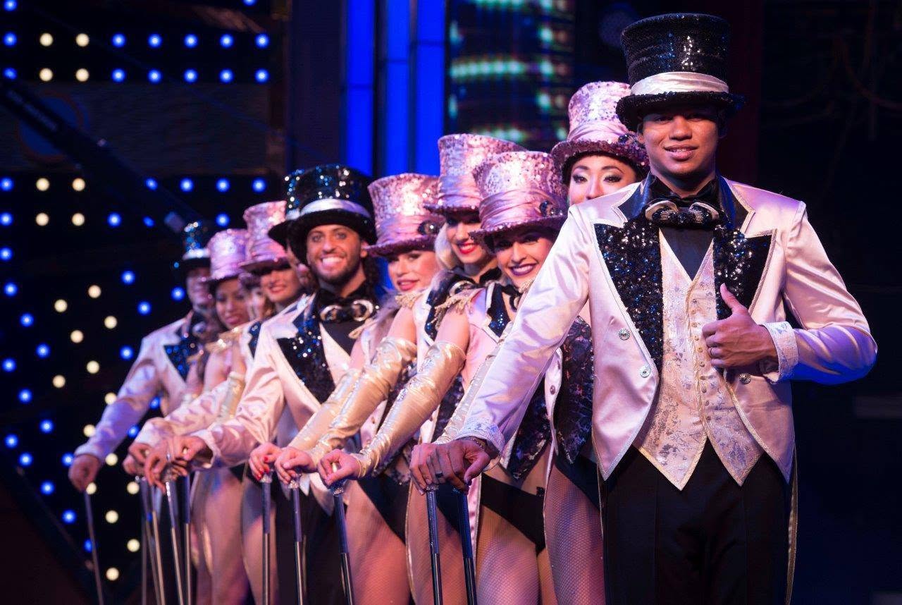 Performers in pink costumes and hats line up for the show finale.